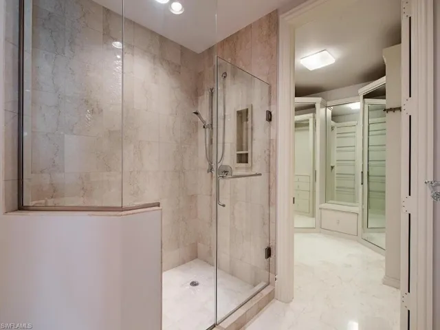Bathroom with a shower stall and marble finish floors