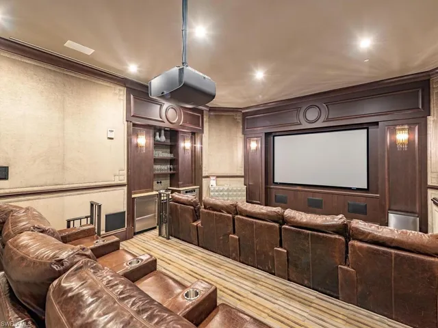 Home theater featuring ornamental molding, a decorative wall, and recessed lighting