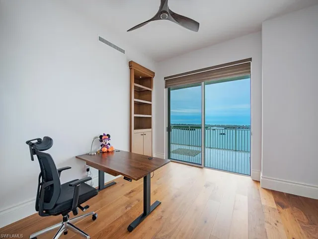 Home office with light wood-type flooring and a ceiling fan