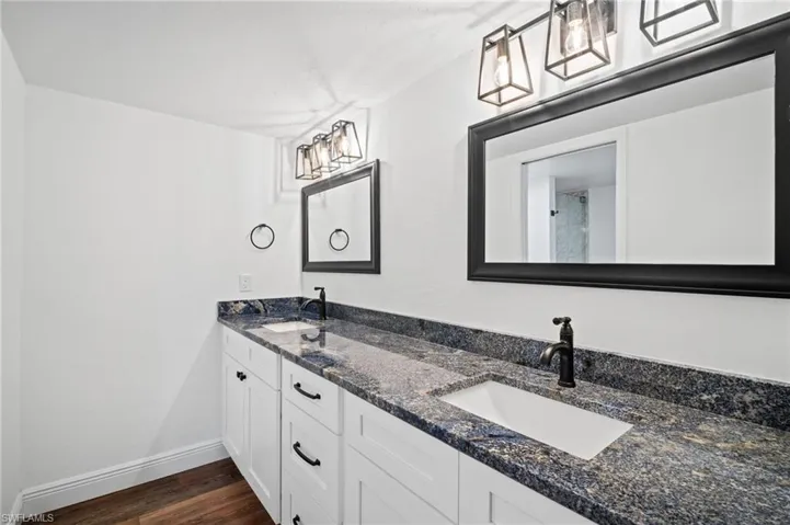 Bathroom featuring dark wood-style floors and double vanity