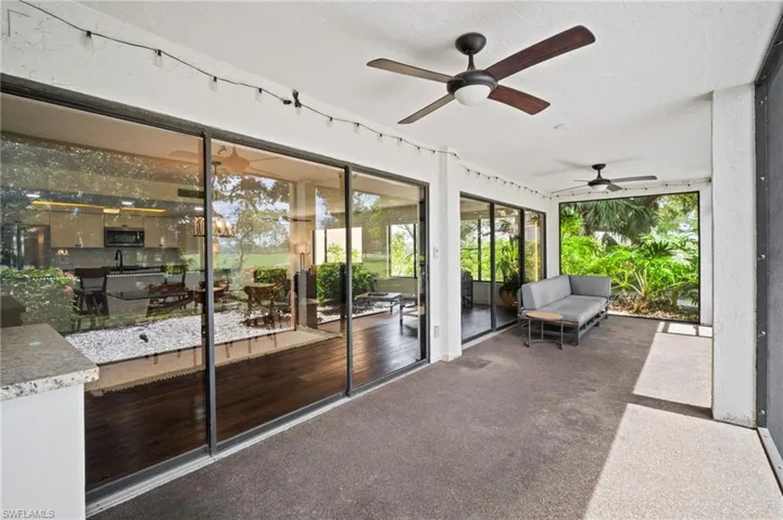 Sunroom featuring ceiling fan and a patio area