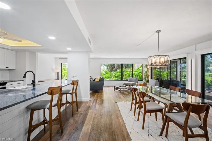 Dining space featuring dark wood-style floors, a chandelier, and recessed lighting
