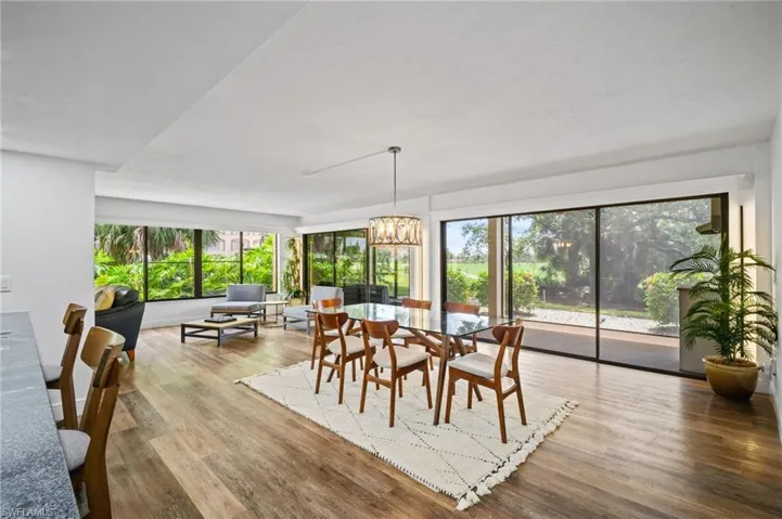 Dining space featuring wood finished floors, a chandelier, and healthy amount of natural light
