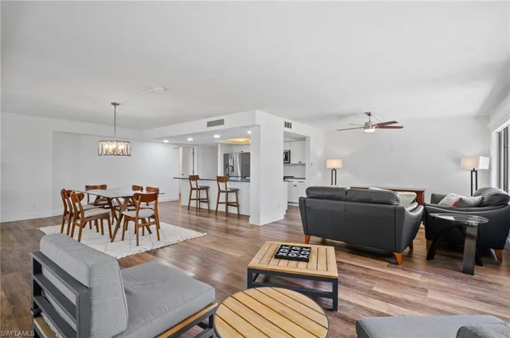 Living room featuring wood finished floors, ceiling fan, and a chandelier