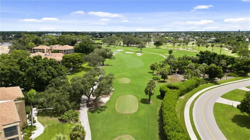 Aerial perspective of suburban area featuring a tree filled landscape and a golf course