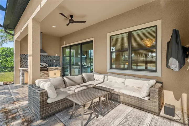 View of patio with exterior kitchen, ceiling fan, and outdoor lounge area