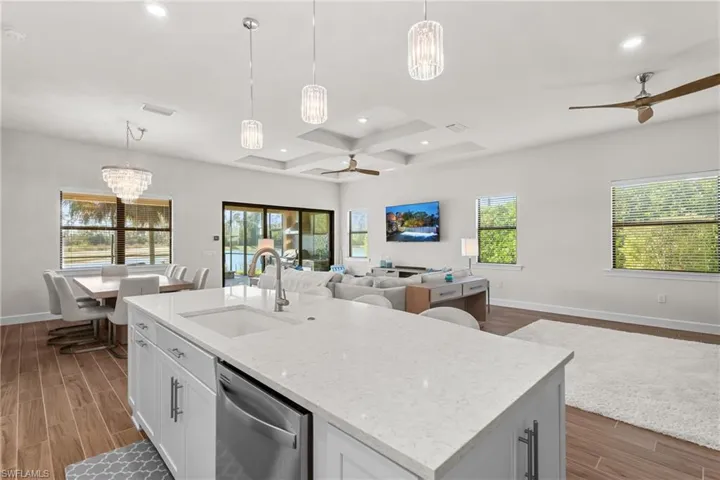 Kitchen with ceiling fan, decorative light fixtures, white cabinetry, a chandelier, and wood tiled floors
