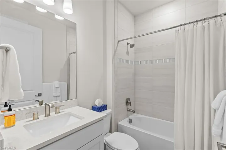 Full bathroom featuring vanity and shower / bathtub combination with curtain