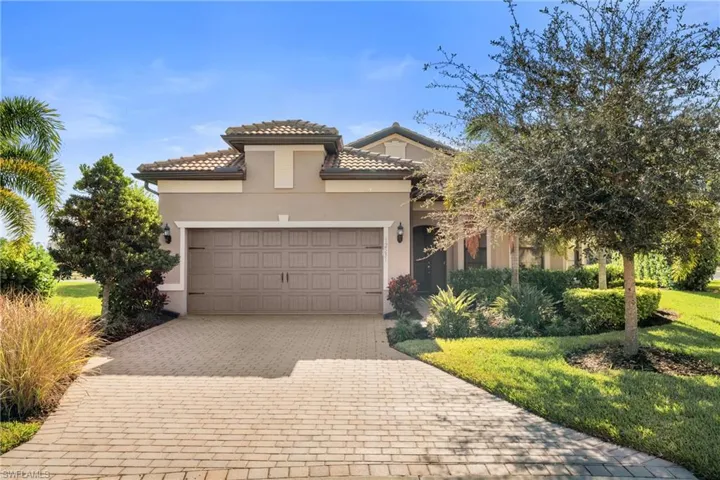 Mediterranean / spanish home featuring decorative driveway, stucco siding, an attached garage, a front yard, and a tile roof
