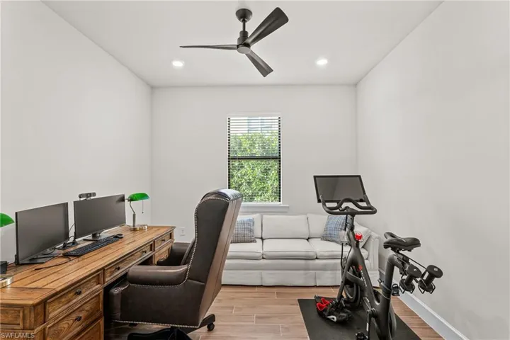 Office area featuring wood tiled floors, ceiling fan, and recessed lighting