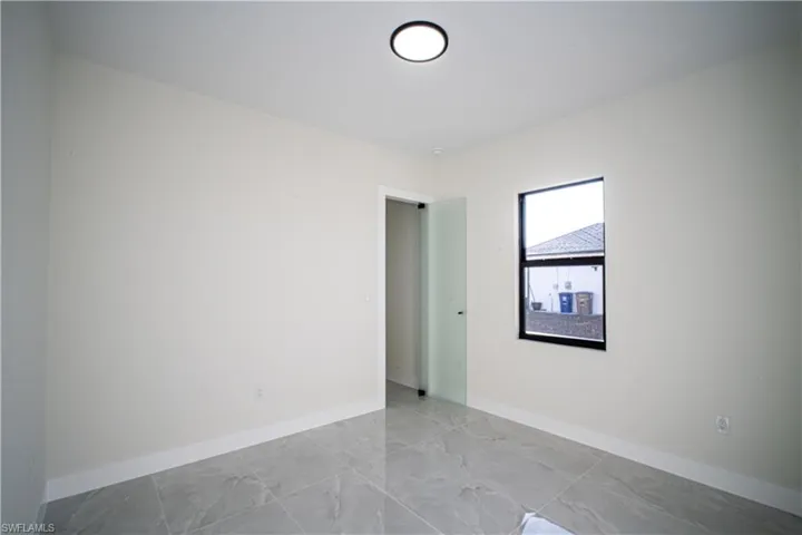 Unfurnished room featuring baseboards and light marble finish flooring