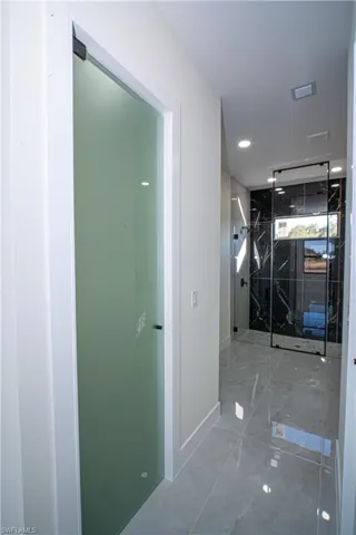 Corridor with recessed lighting and marble finish floors