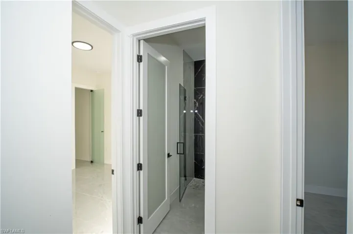 Corridor with baseboards and light marble finish floors