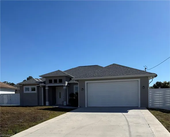 View of front of house featuring an attached garage, stucco siding, driveway, and a shingled roof