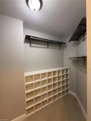 Walk in closet with light wood-type flooring