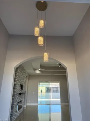 Detailed view of a tray ceiling, a fireplace, and arched walkways