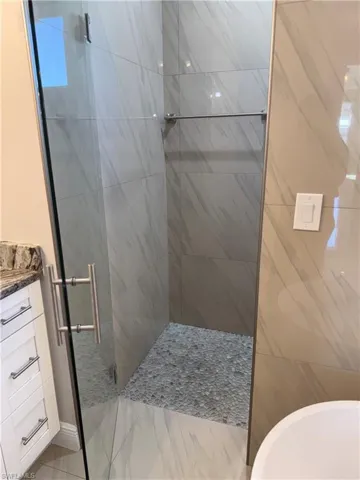 Full bathroom featuring vanity and a shower stall