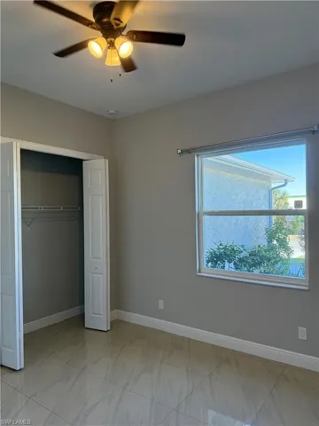Unfurnished bedroom 2 featuring ceiling fan and a closet