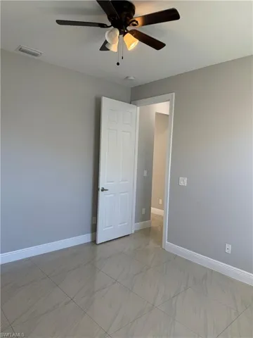 Unfurnished bedroom 1 with baseboards and a ceiling fan