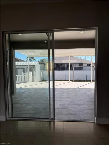 Exit to patio featuring healthy amount of natural light and tile patterned flooring