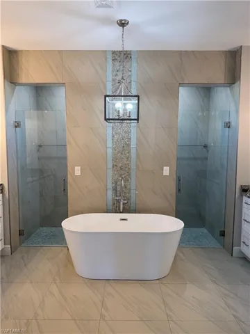 Full bathroom featuring a freestanding bath, tile walls, a shower stall, and vanity
