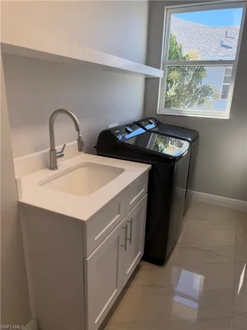 Laundry room with separate washer and dryer and cabinet space