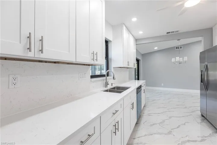 Kitchen featuring a sink, visible vents, white cabinetry, stainless steel refrigerator with ice dispenser, and dishwasher