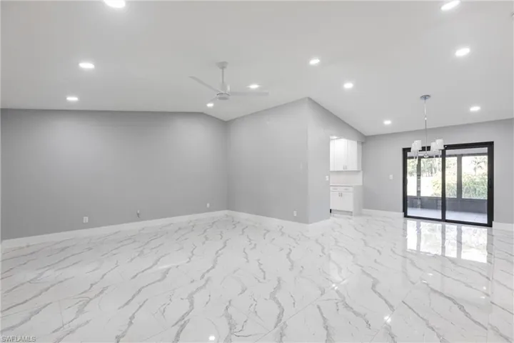 Empty room with baseboards, recessed lighting, lofted ceiling, a ceiling fan, and marble finish floor
