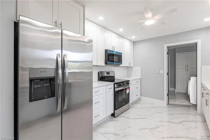Kitchen with baseboards, recessed lighting, a ceiling fan, light countertops, and appliances with stainless steel finishes