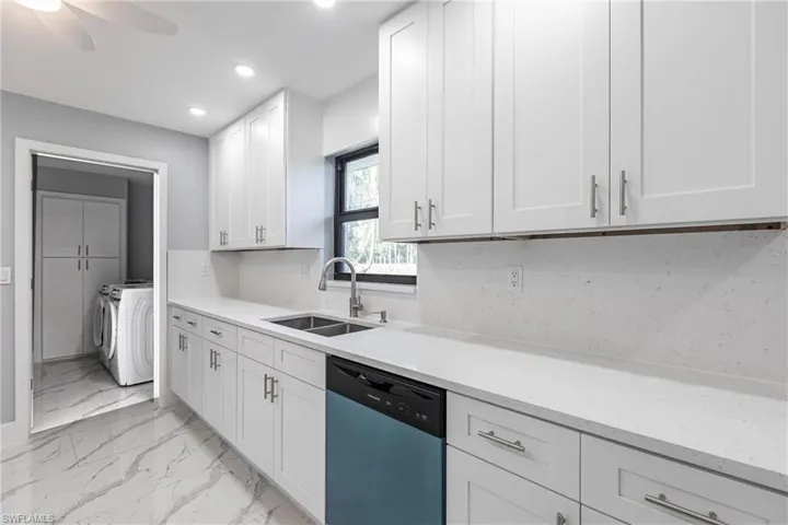 Kitchen featuring a sink, washing machine and dryer, recessed lighting, dishwashing machine, and ceiling fan