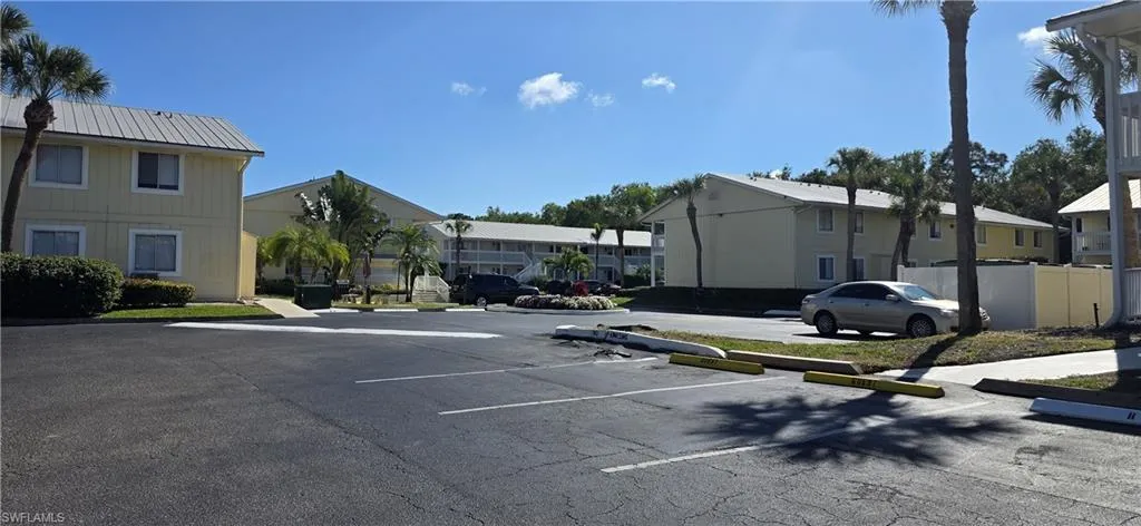 Uncovered parking lot featuring a residential view