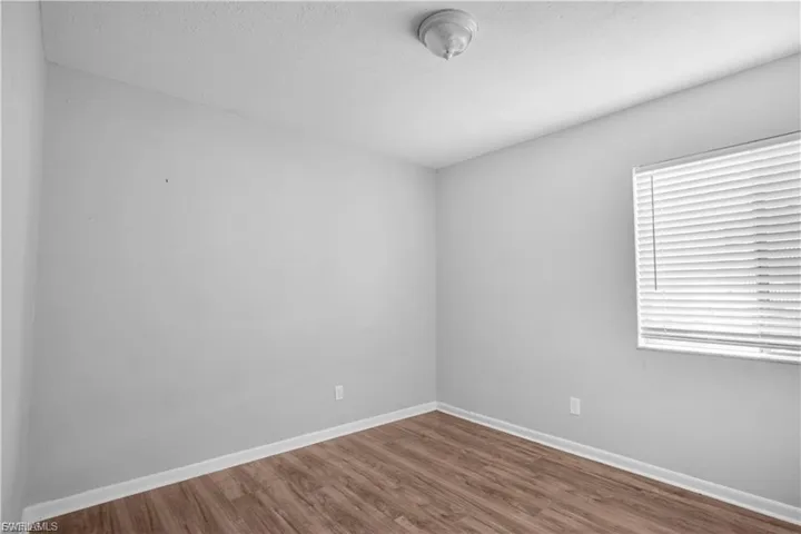 Unfurnished room with wood finished floors and a textured ceiling