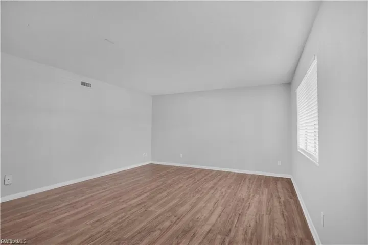Unfurnished room featuring wood finished floors and baseboards