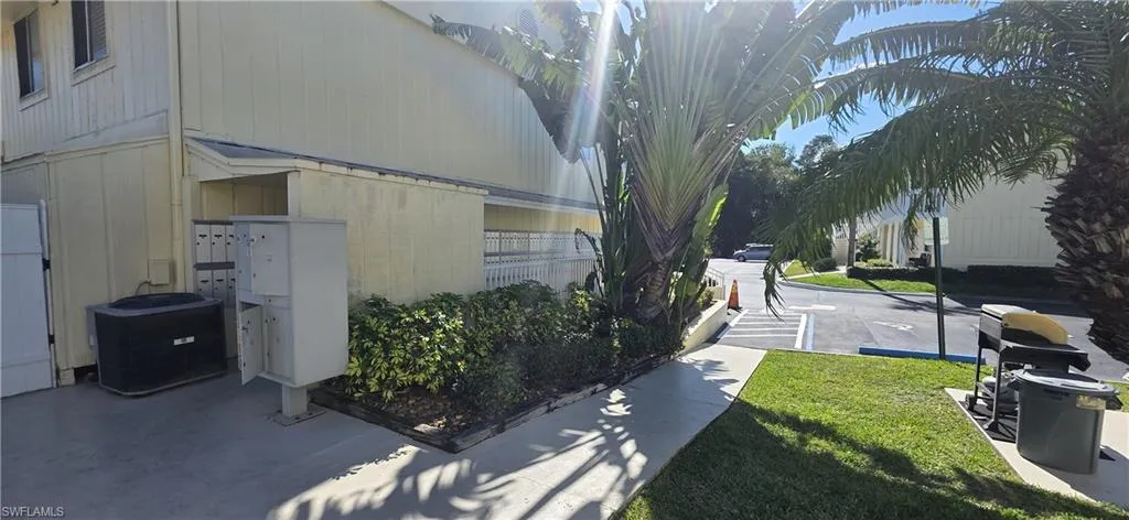 View of property exterior with mail area and a lawn