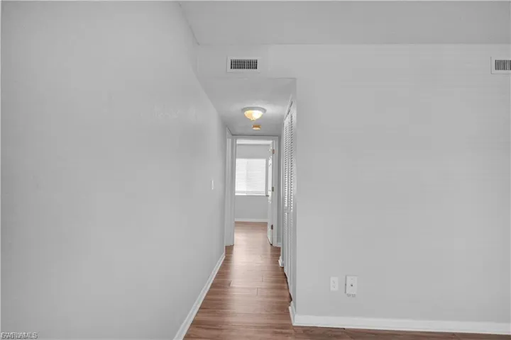Corridor featuring baseboards and wood finished floors