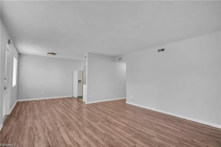 Unfurnished room featuring wood finished floors and baseboards
