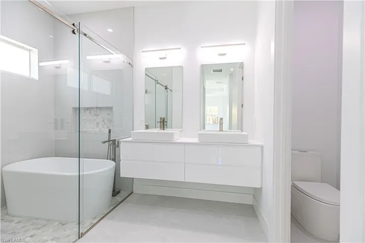 Full bath featuring double vanity, a soaking tub, and a shower stall