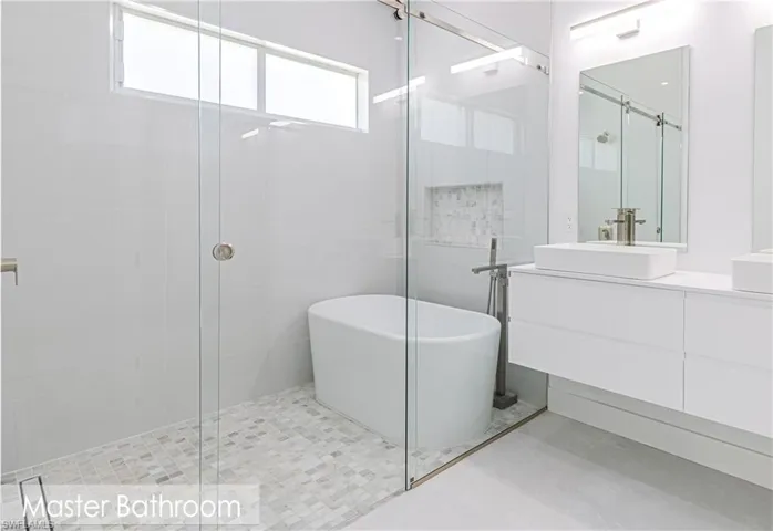 Full bathroom with a freestanding tub, vanity, and a shower stall