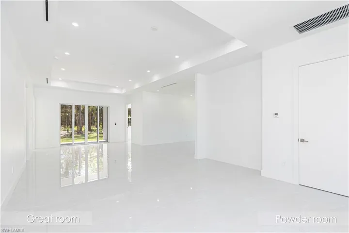 Empty room featuring a raised ceiling, marble finish floor, visible vents, and recessed lighting