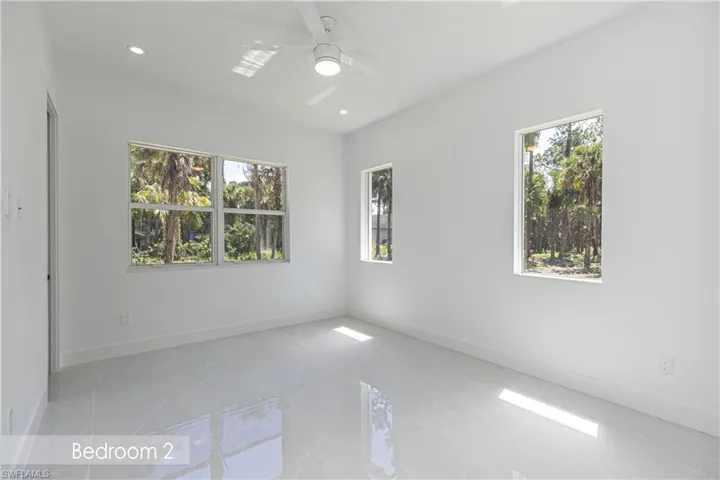 Spare room with a healthy amount of sunlight, baseboards, and a ceiling fan