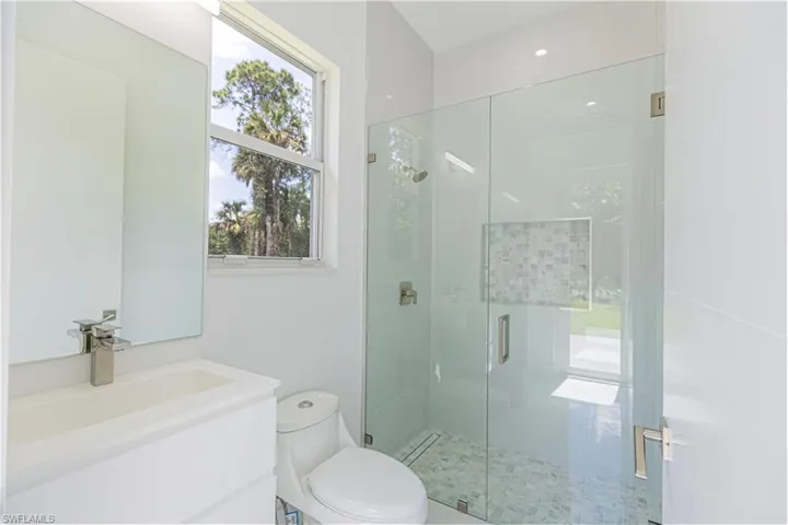 Full bathroom with a shower stall, vanity, and toilet