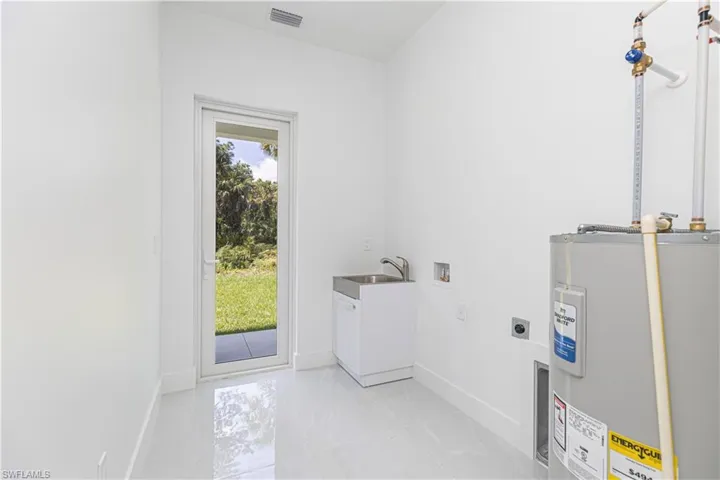 Washroom with water heater, washer hookup, and hookup for an electric dryer