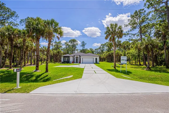 Ranch-style house with an attached garage, driveway, and a front lawn