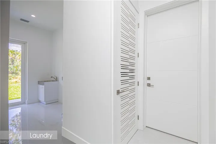 Hallway with a sink, baseboards, and visible vents