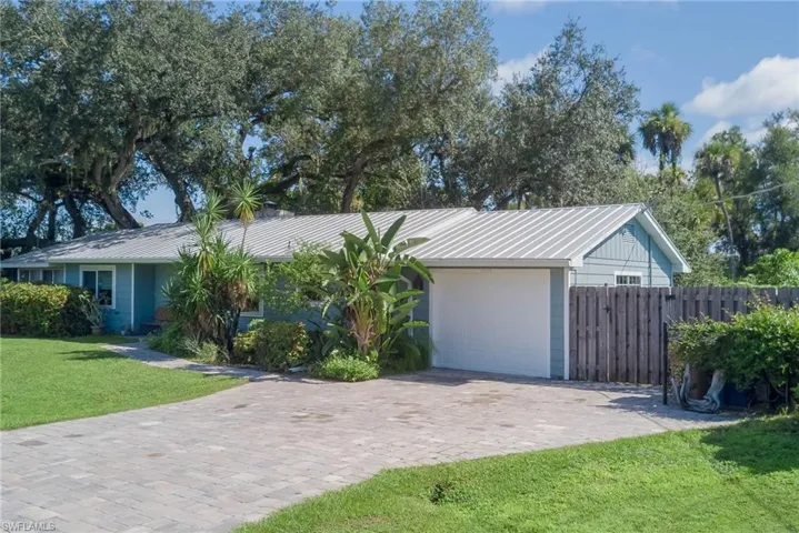 Ranch-style house with a metal roof and driveway