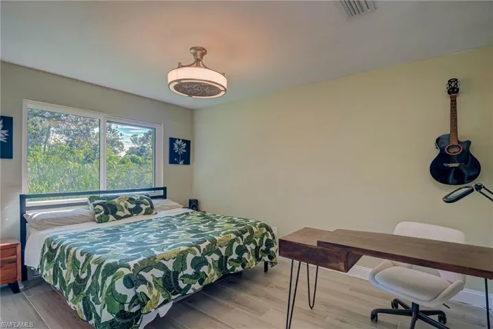 Bedroom with wood finished floors and baseboards