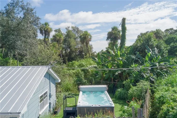 View of pool with a hot tub and view of scattered trees