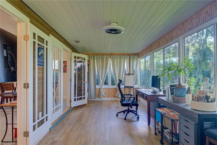 Office space with wood finished floors, wooden ceiling, wood walls, and french doors