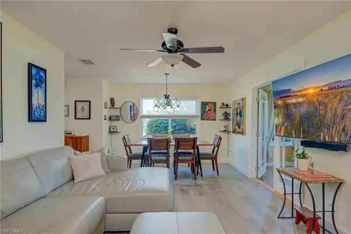 Living room featuring wood finished floors, a chandelier, and ceiling fan