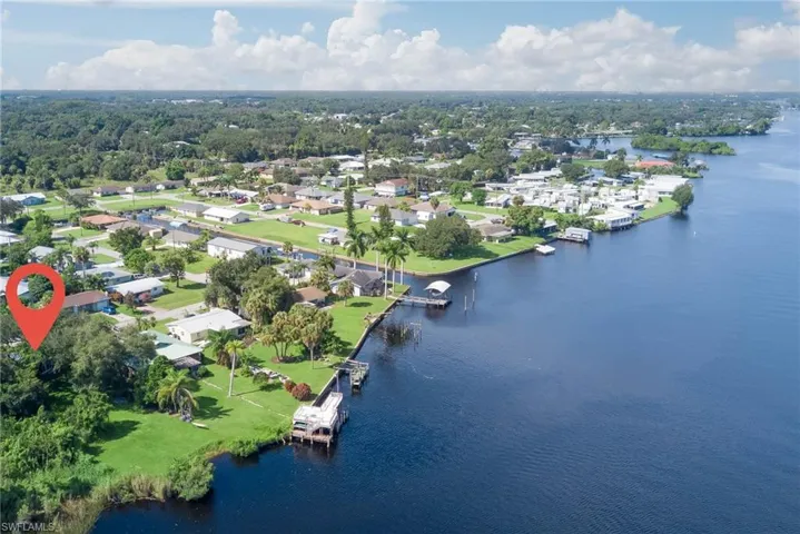 Aerial perspective of suburban area featuring a nearby body of water